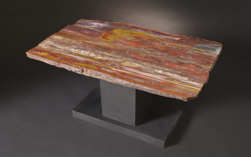 Extremely colorful petrified wood table with a quartz pocket on a custom iron base